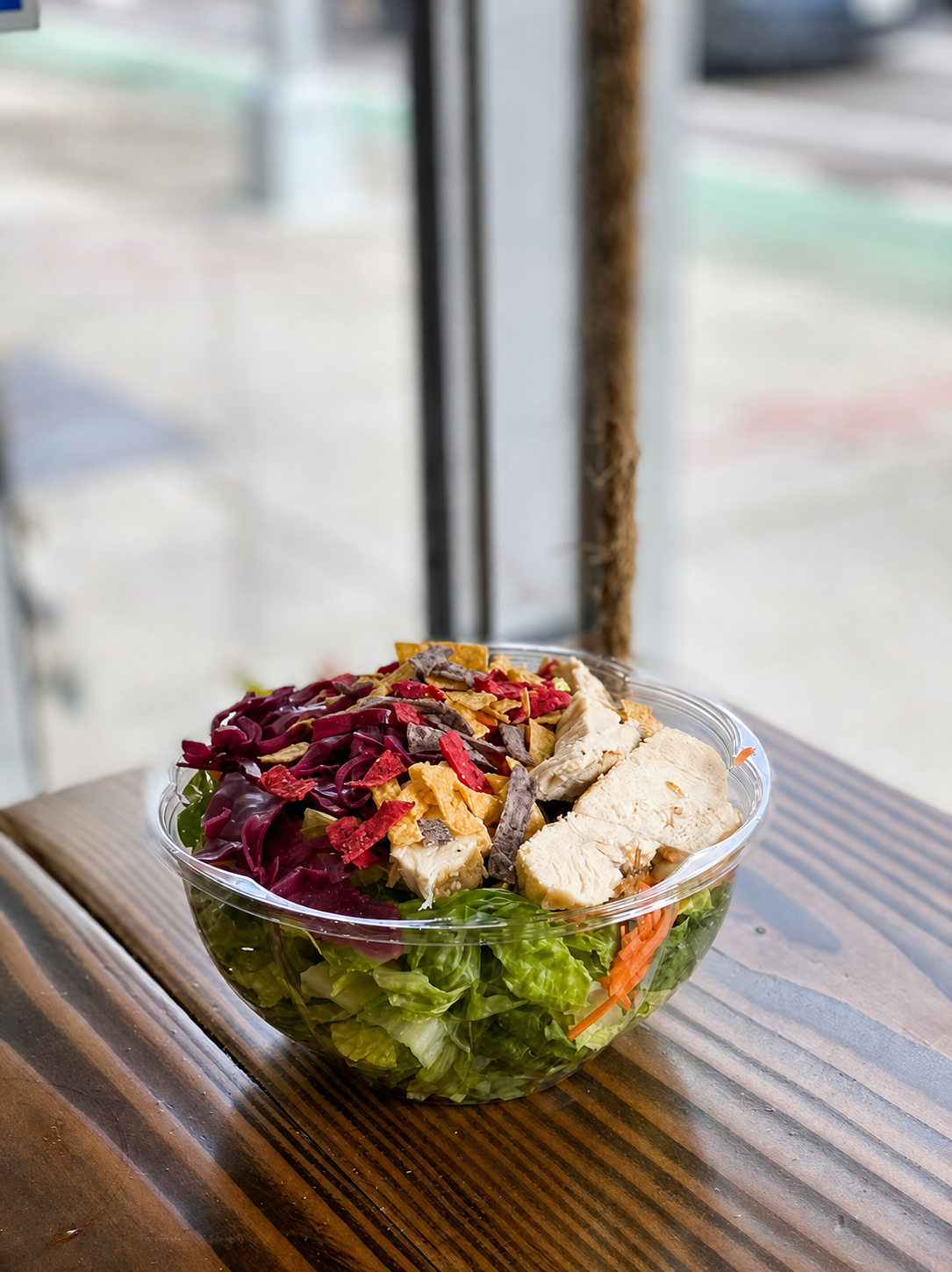 Fresh salad bowl with chicken, greens, cabbage, and tortilla strips
